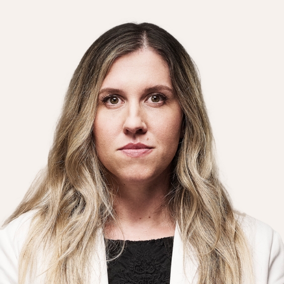 Female Heartland Supported Doctor in a white coat and dark blouse