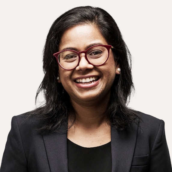 Female Heartland Supported Doctor with glasses wearing a dark suit