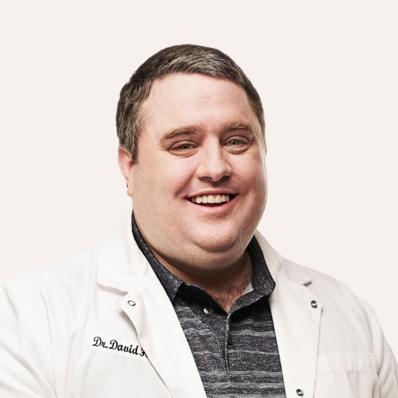 Close up of smiling male dentist wearing a white lab coat