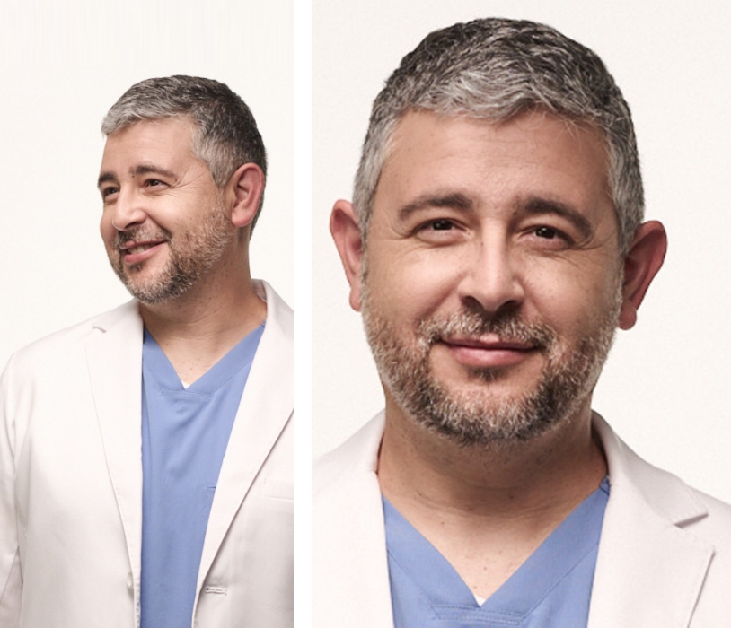 Confident middle-aged male doctor in a white lab coat and blue scrubs