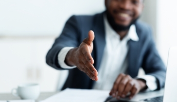 A business professional extending his hand for a handshake