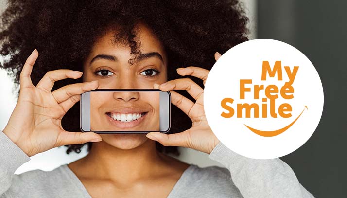 woman holding phone over mouth showing perfect smile